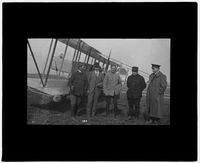 Five men in front of biplane