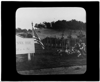 An American flag beside a cemetery sign