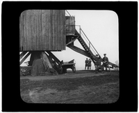 Men and wagons beneath the windmill