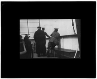 Three men looking off the side of the ship